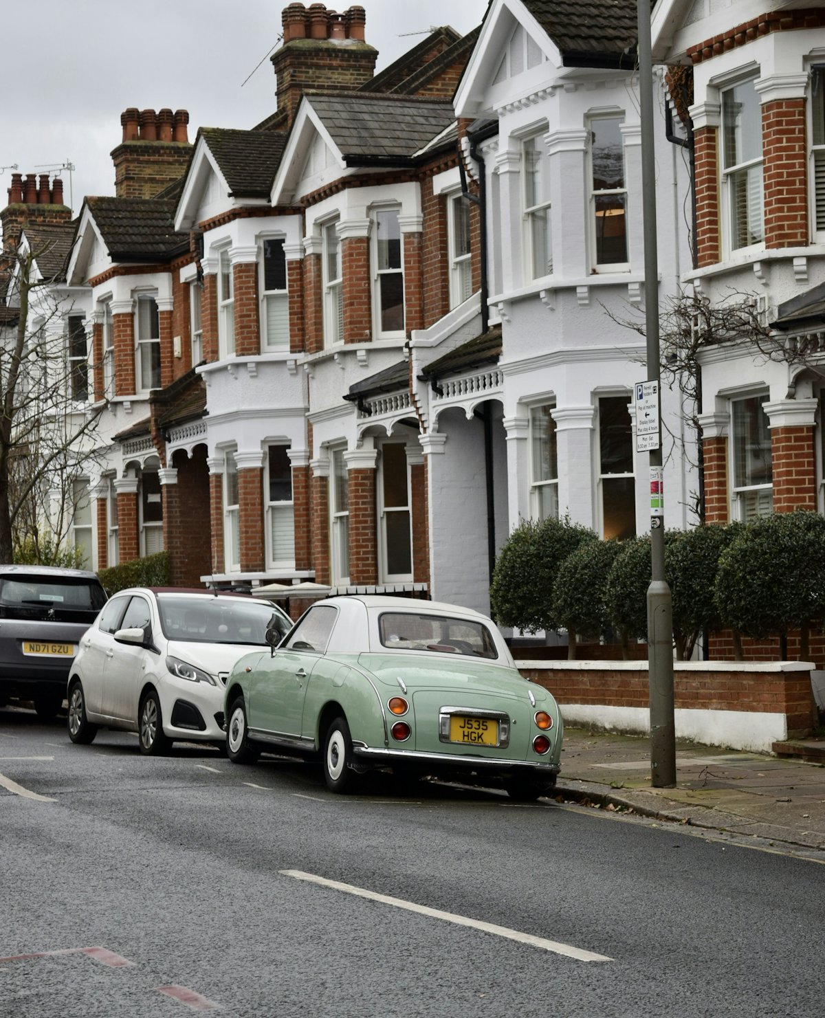 Victorian terraced houses on a London street with cars parked outside